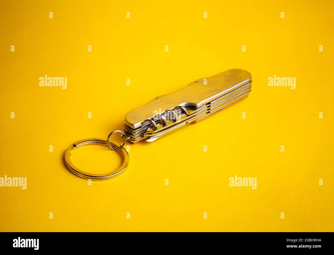 multifunctional metal knife on a yellow background. Stock Photo