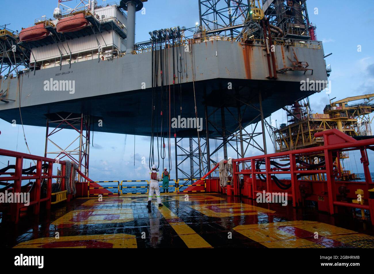 marine crew stand by on deck vessel for personal transfer from platform to vessel Stock Photo