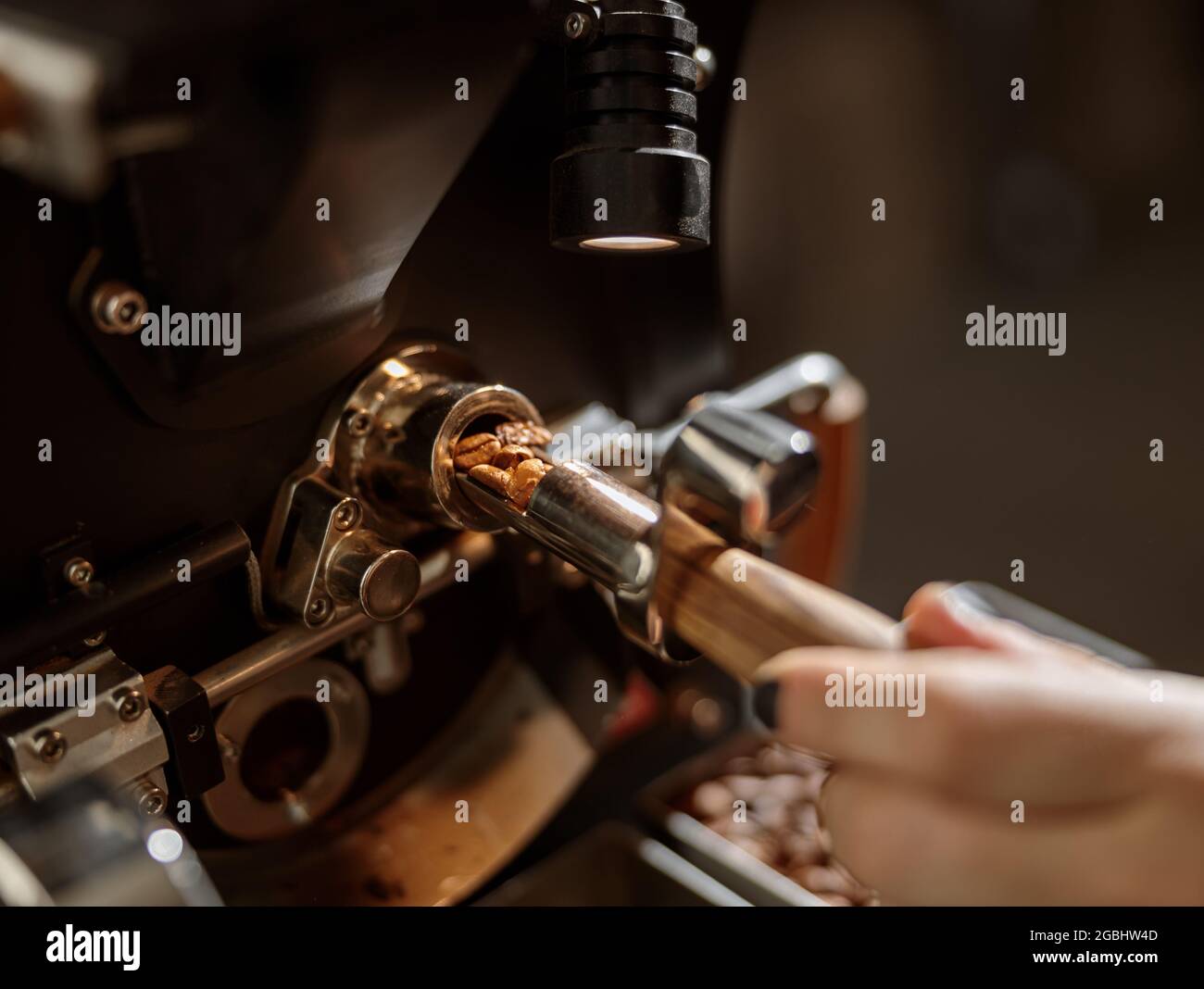 Male worker using professional coffee roasting machine Stock Photo