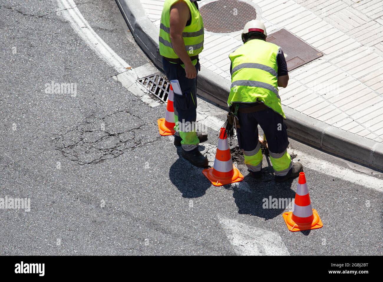 Workers repairing an asphalt road on city. Paving maintenance Stock Photo