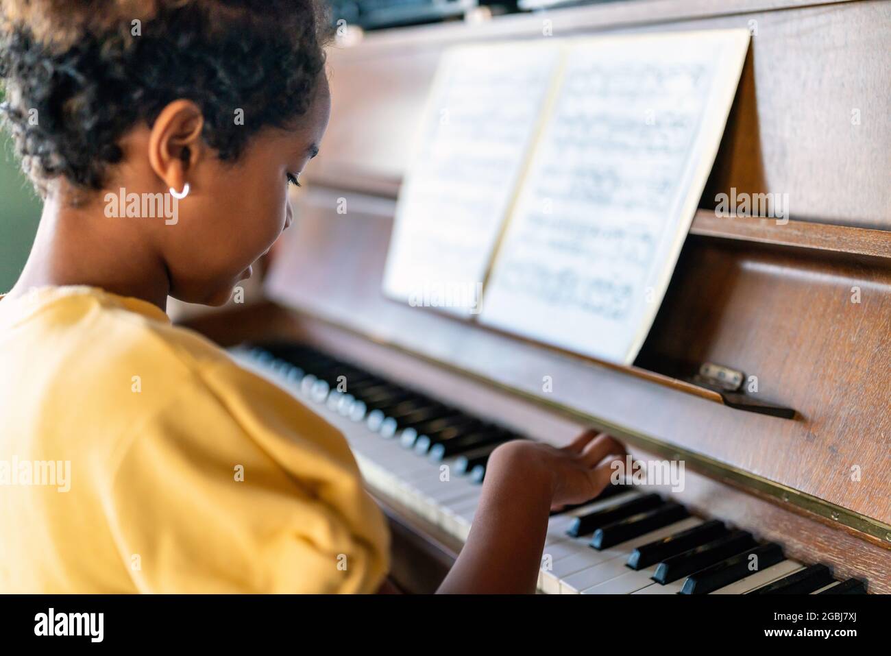 Musical education. Happy black girl playing the piano Stock Photo - Alamy