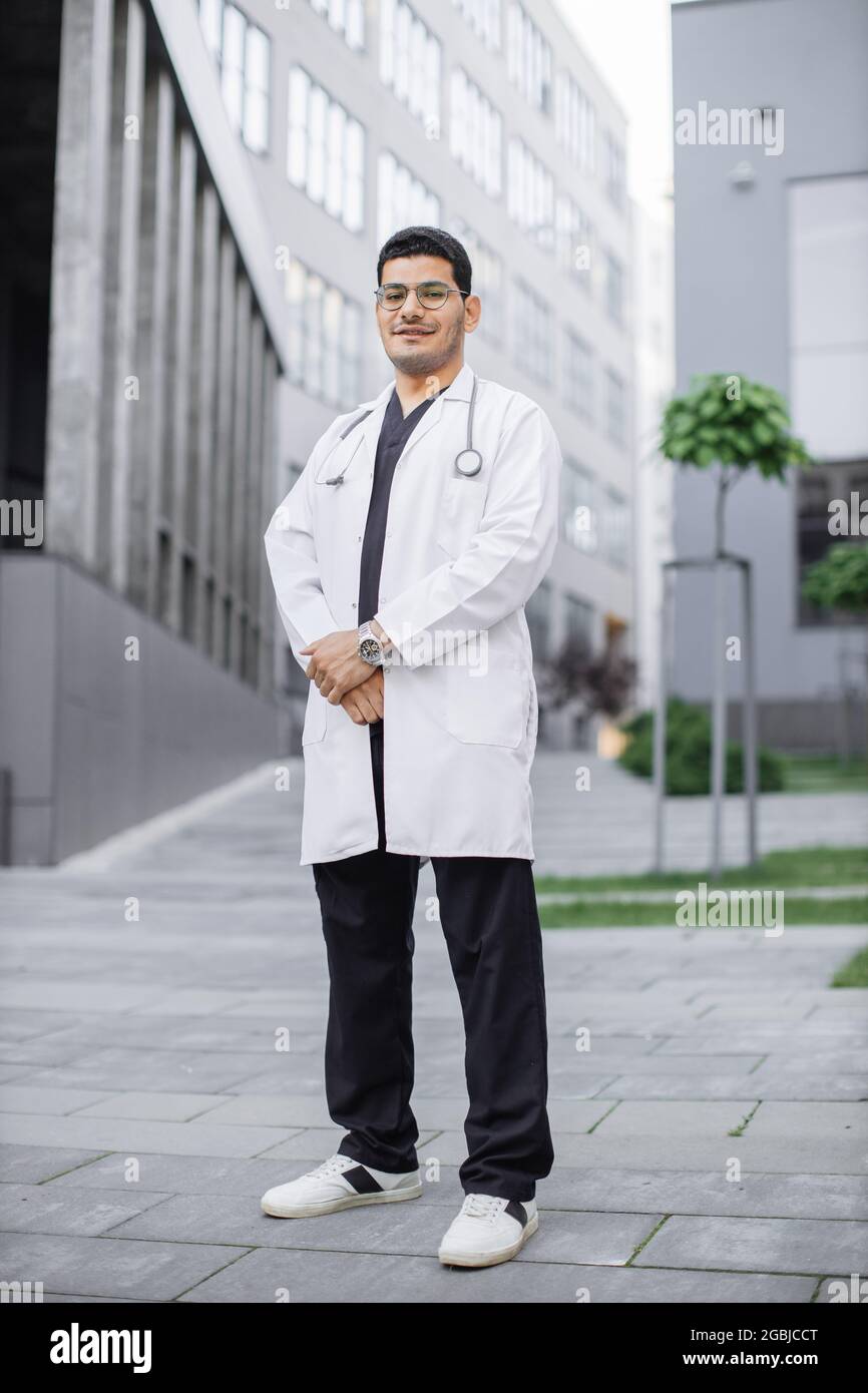 A young handsome Saudi Arabian male doctor smiling outside hospital
