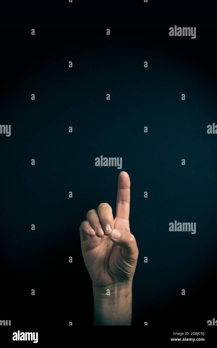 Dramatic colour image of male hand demonstrating ASL American sign language letter D with empty copy space for editors Stock Photo