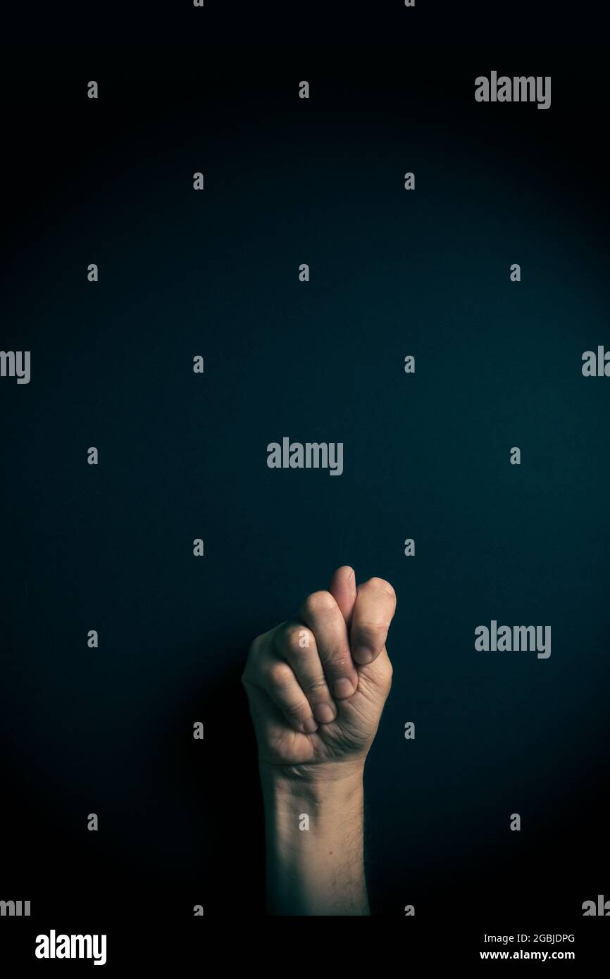 Dramatic colour image of male hand demonstrating ASL American sign