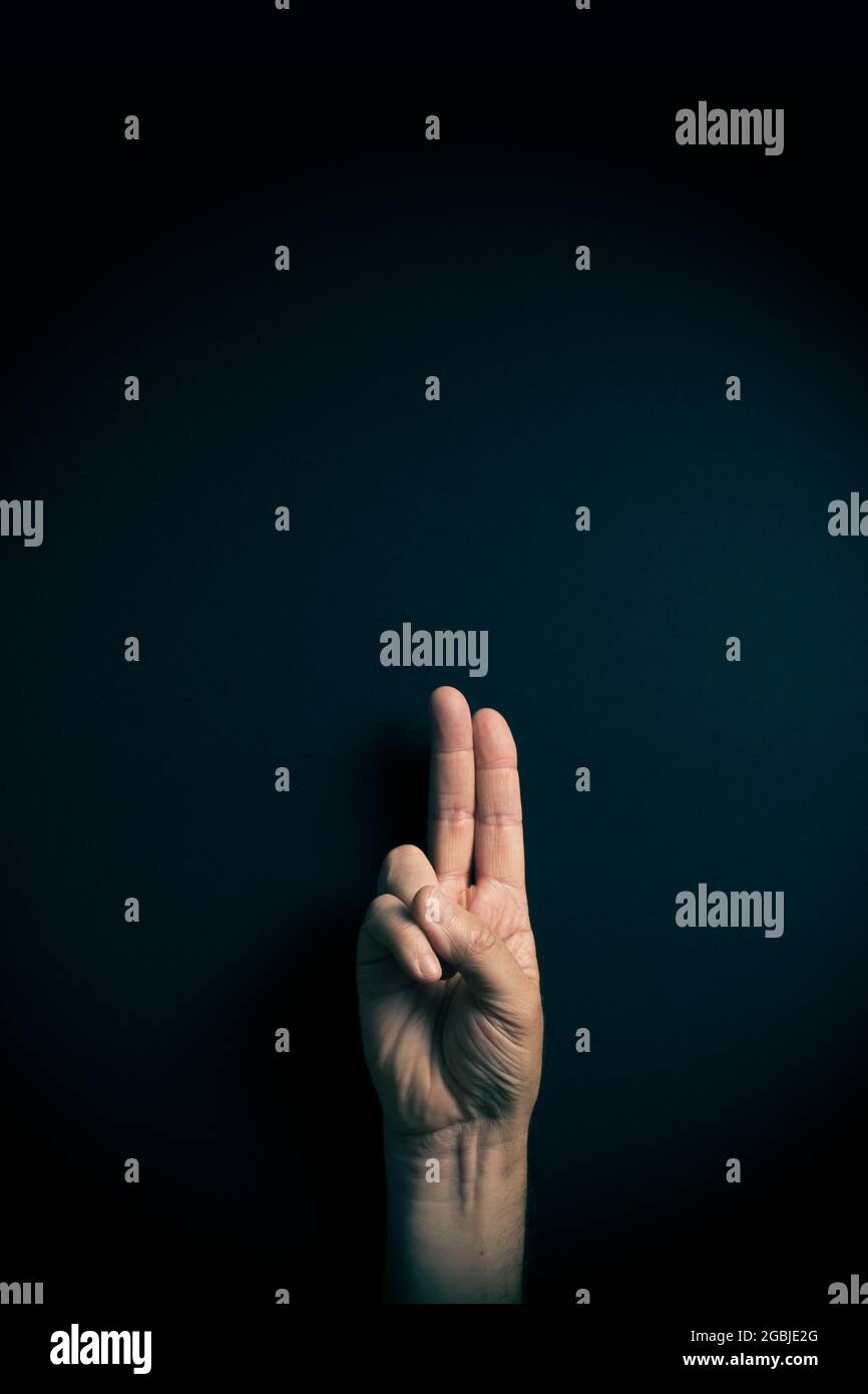 Dramatic colour image of male hand demonstrating ASL American sign ...