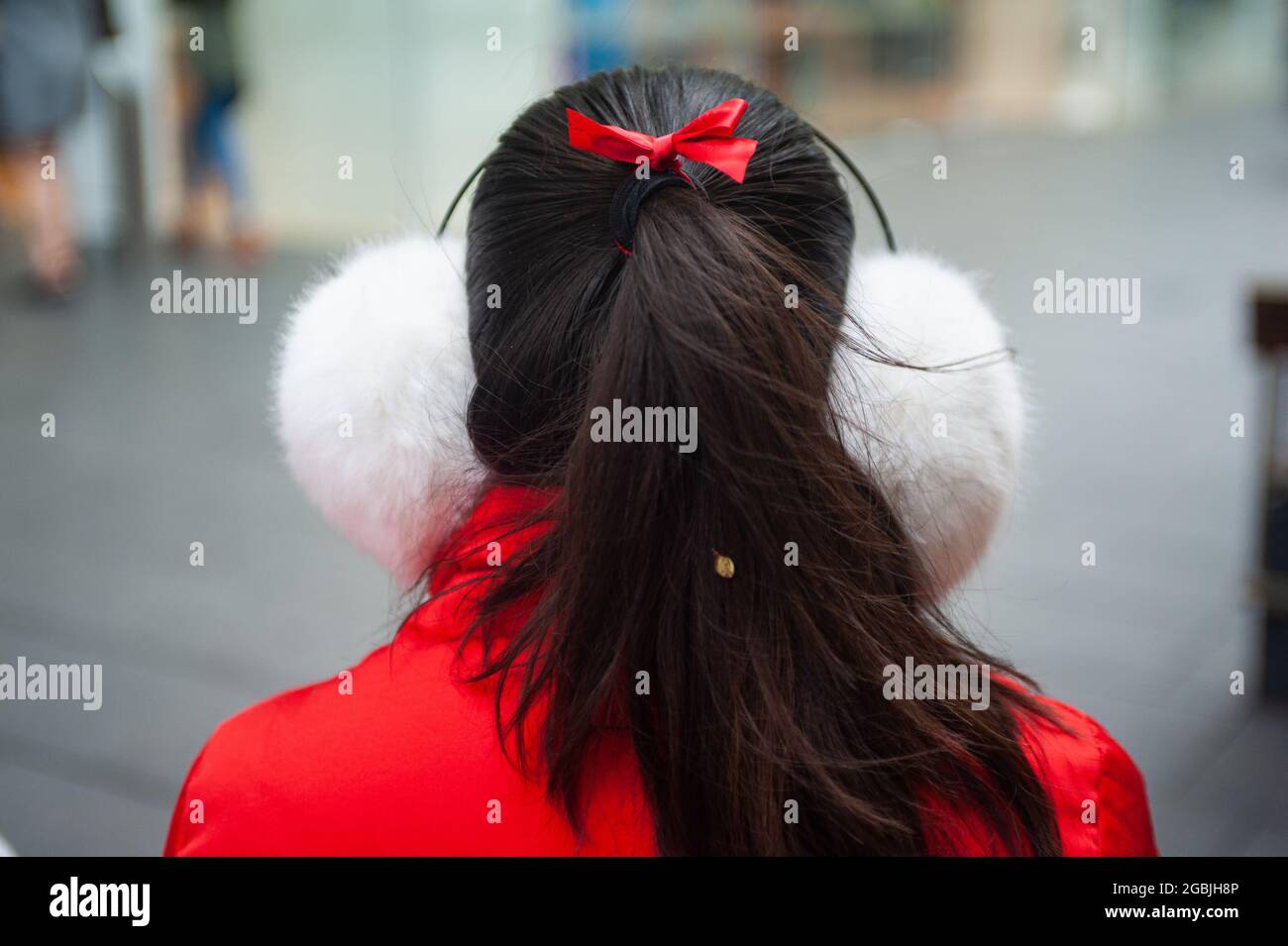 12.05.2018, Sydney, New South Wales, Australia - A young woman is seen wearing fluffy cold-weather thermal earmuffs on a cool day. Stock Photo