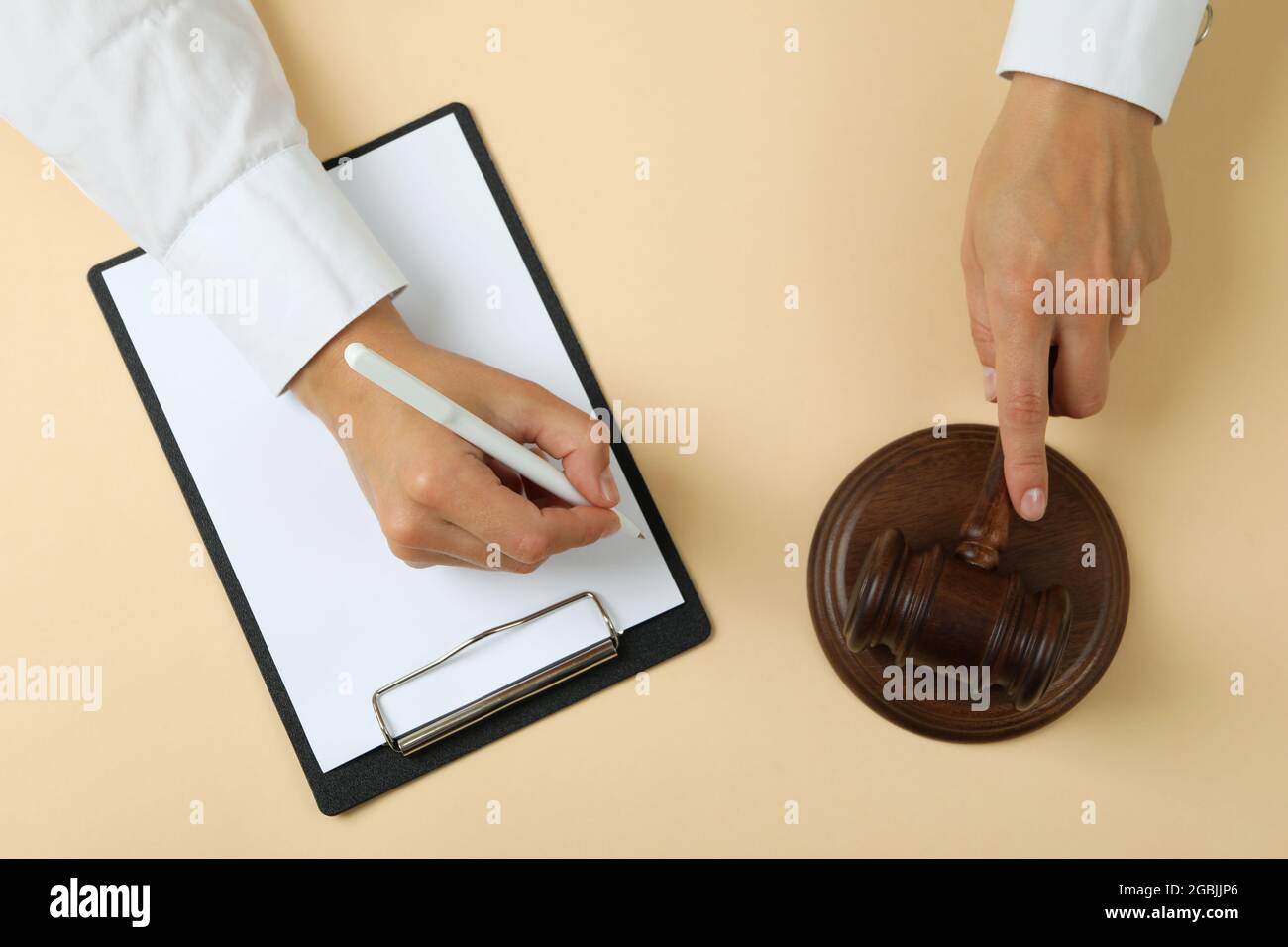 Female judge hands hold gavel and make notes in clipboard Stock Photo