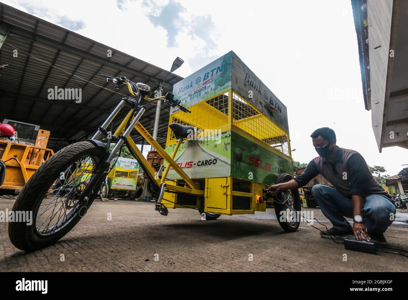 An officer is seen charging an electric bicycle at a Office the Department of Environment in Bogor, West Java, Indonesia, on August 4, 2021. The electric bicycle that carries waste that does not emit exhaust gas emissions and is more environmentally friendly can cover a distance of 25 km and has a capacity of 200 kilograms to accommodate non-organic waste. (Photo by Andi M. Ridwan/INA Photo Agency/Sipa USA) Stock Photo