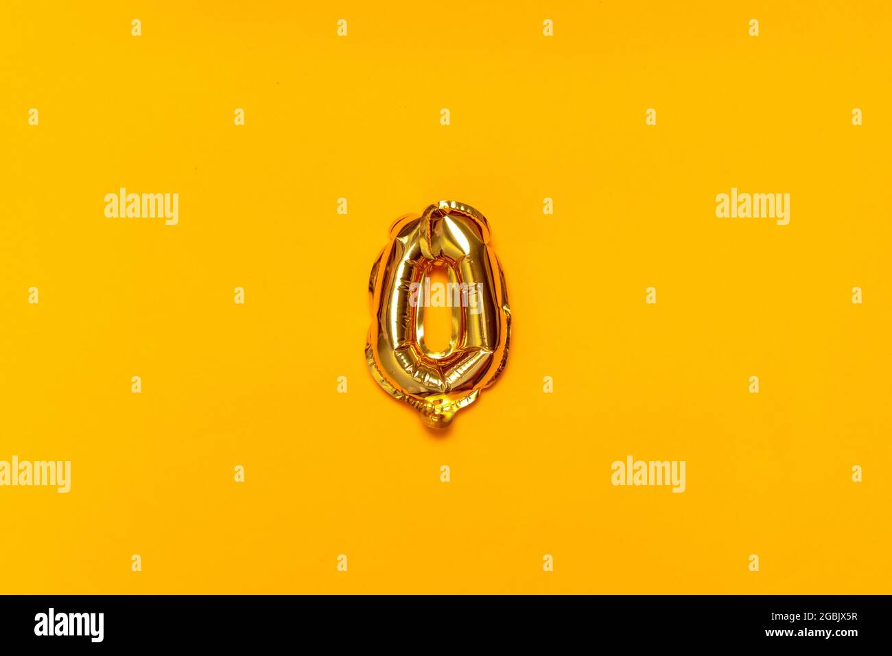 Gold glitter metal zero balloon isolated on a yellow background. Ideal ...