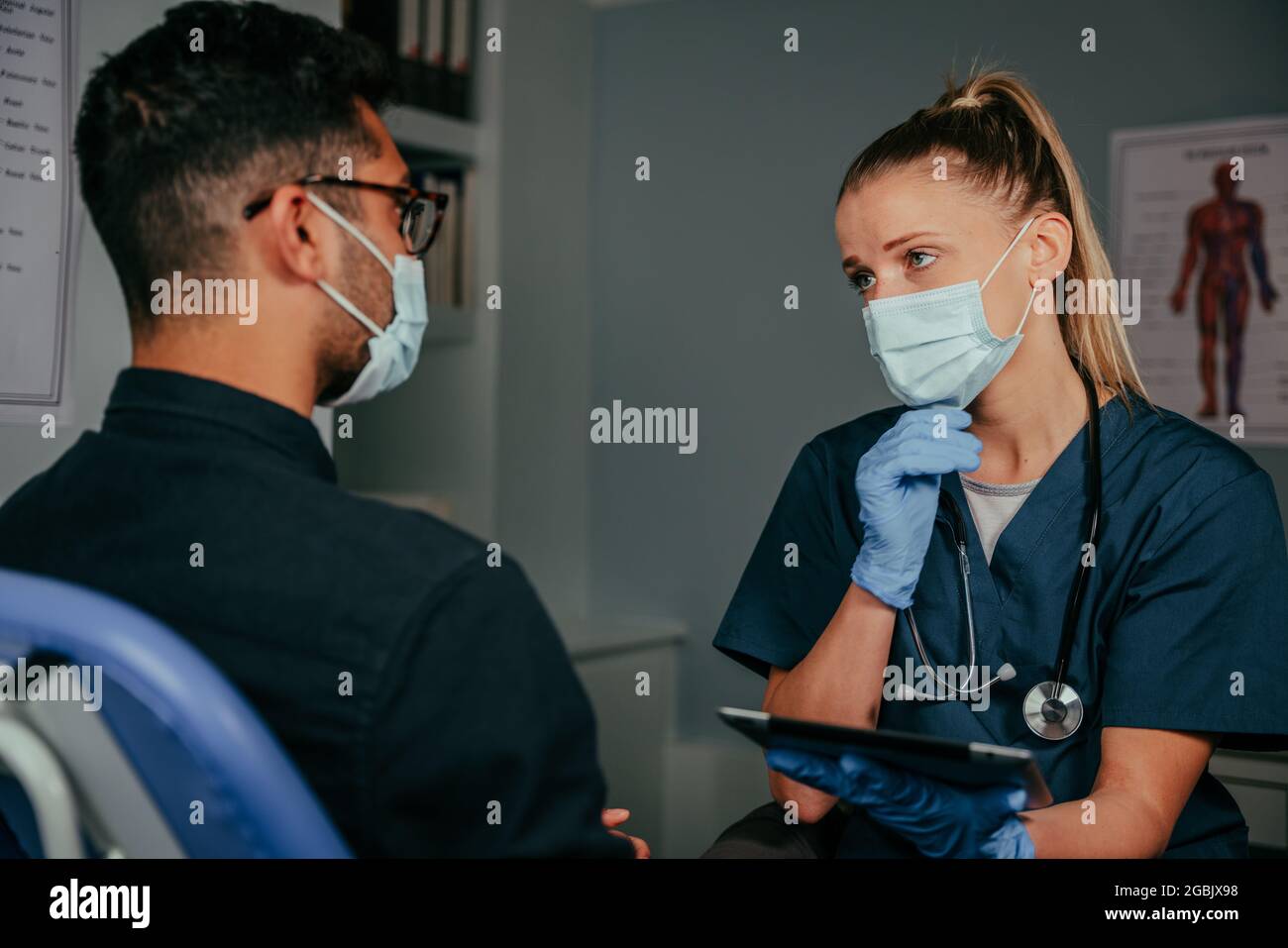 Mixed race male patient chatting to female nurse Stock Photo