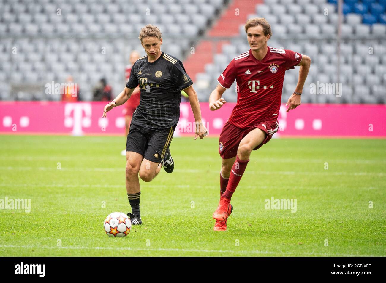 Munich, Germany. 04th Aug, 2021. Football: Bundesliga, team presentation  and training FC Bayern at the Allianz Arena before the start of the season. Tim  Bendzko, musician (l), tries to take the ball