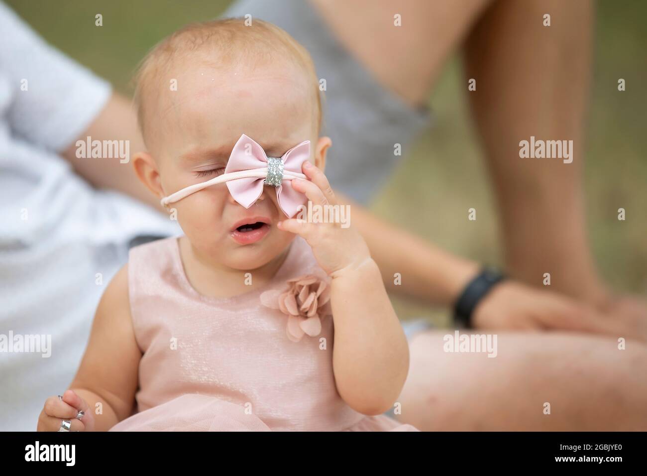 A funny little girl removes a beautiful jewelry from her head. The child is one year old Stock Photo Alamy