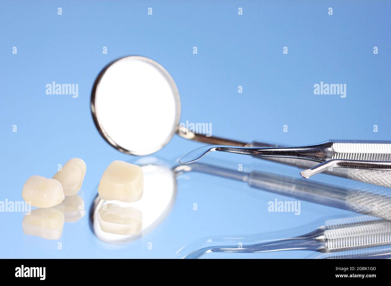 dental mirror with denture teeth on blue background Stock Photo - Alamy