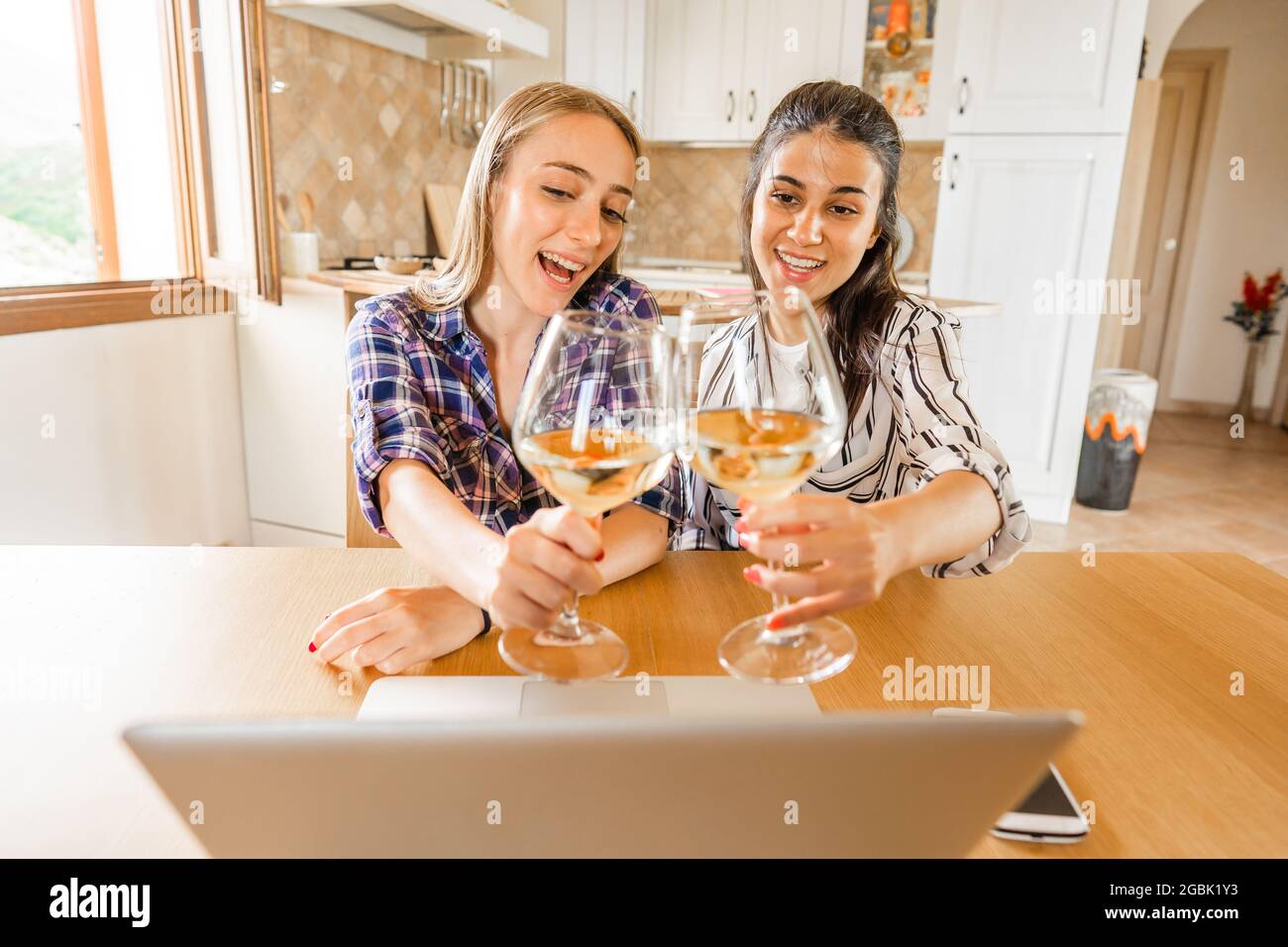 Two Happy Girls Celebrating At Home Drinking Champagne Looking At Laptop Screen Connected In Chat With Parents Or Friends New Normal Way To Make A Pa Stock Photo Alamy