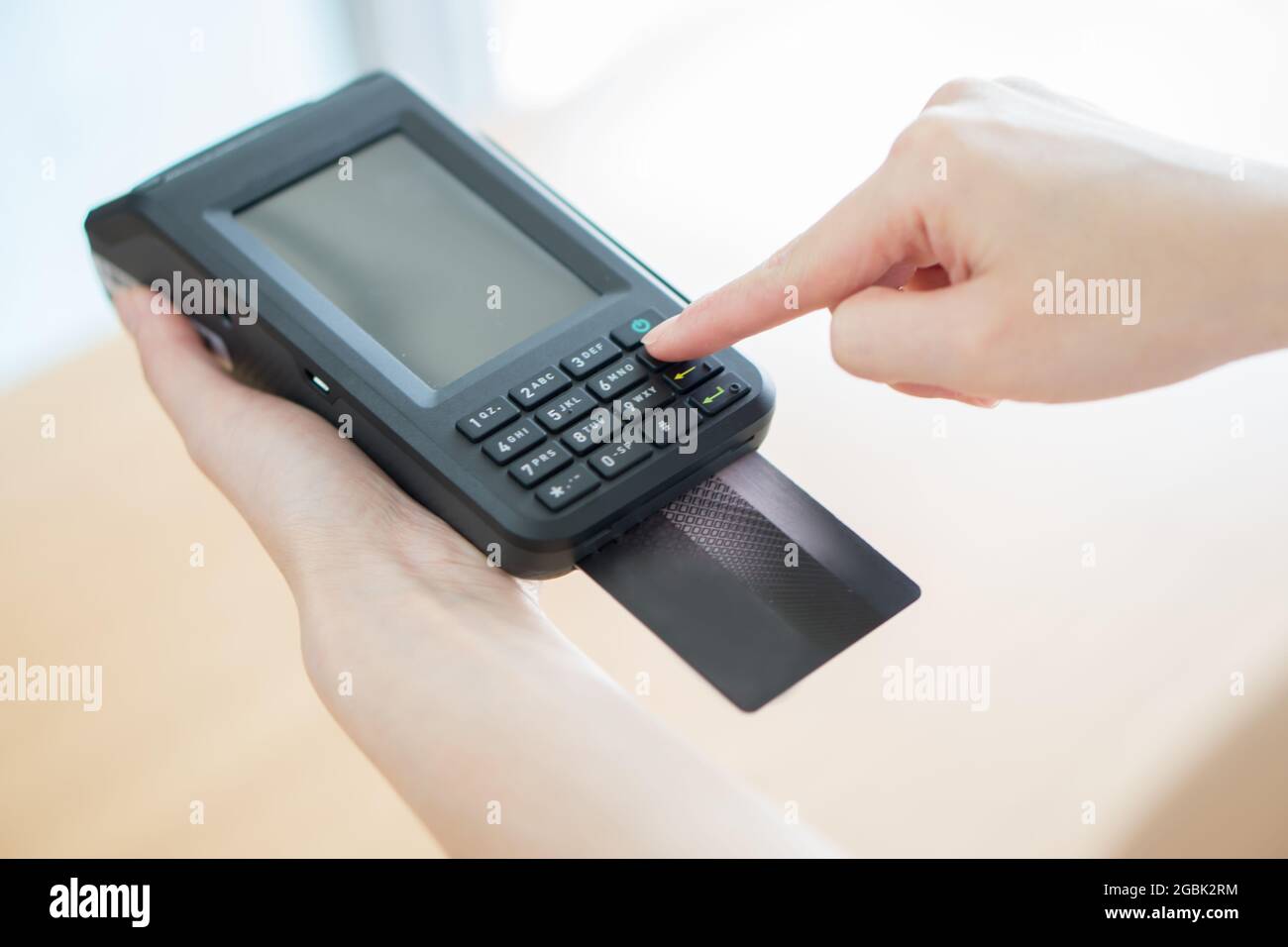 Hand with credit card swipe through terminal Stock Photo