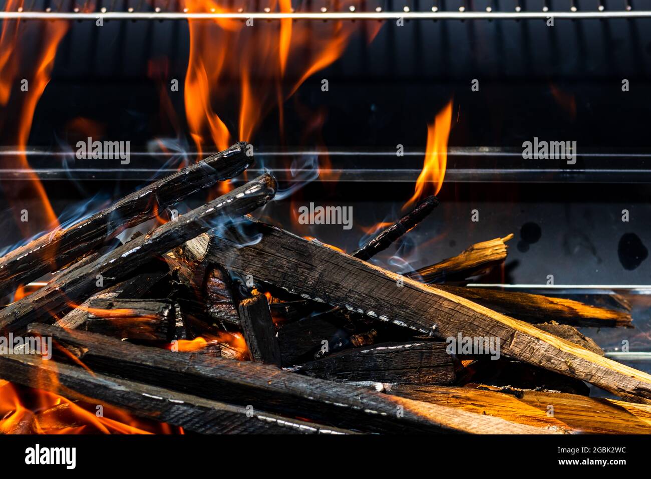 Barbecue grill pit with glowing and flaming hot open fire Stock Photo