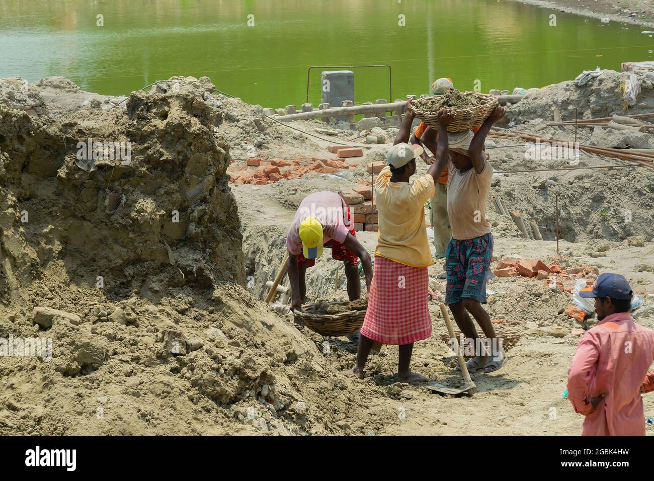 Howrah, West Bengal, India - 7th May 2017 : Indian male workers digging and carrying out soil at buliding construction site. India has a huge populati Stock Photo