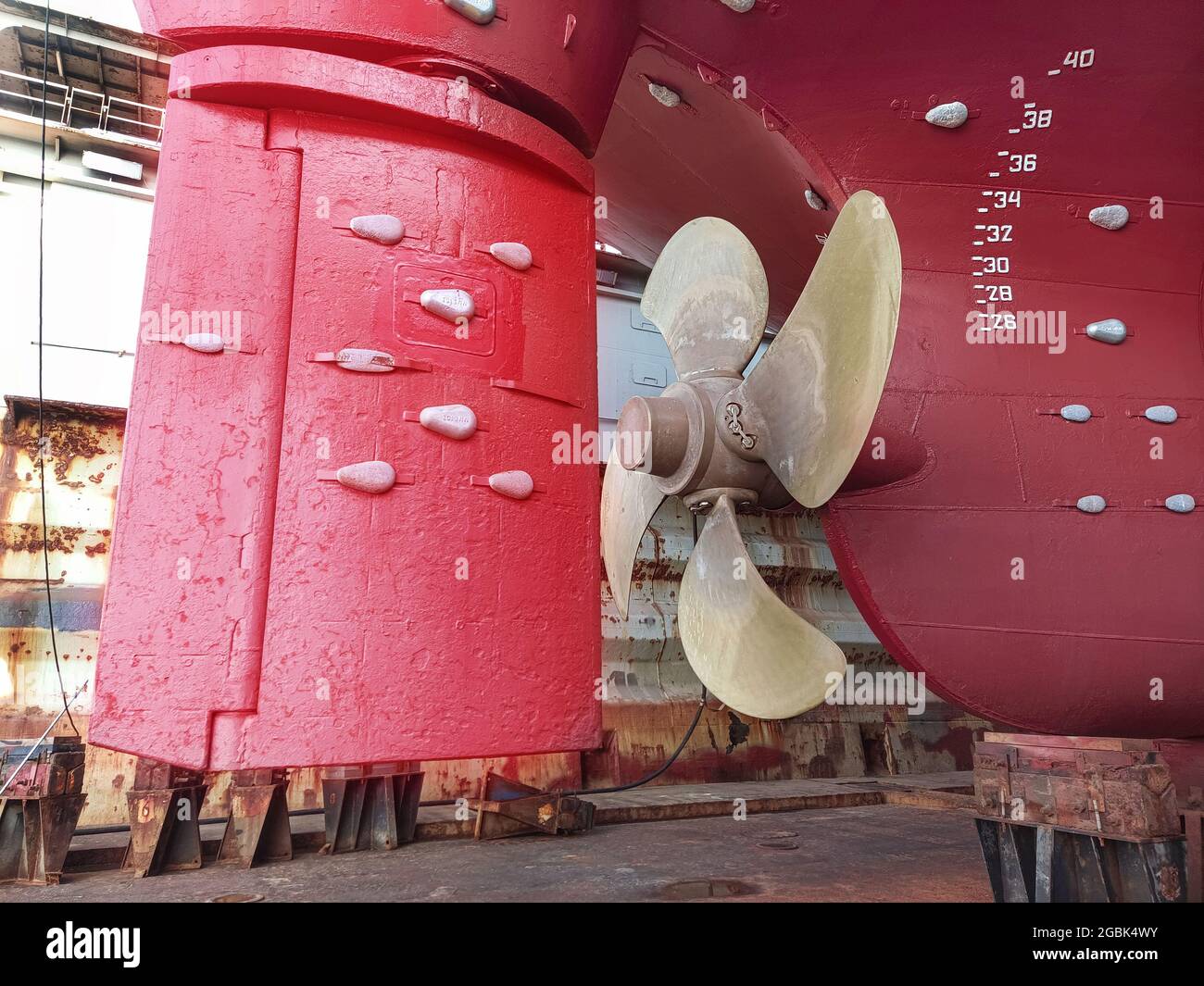 The stern of a large ship with a copper propeller, with a steering gear