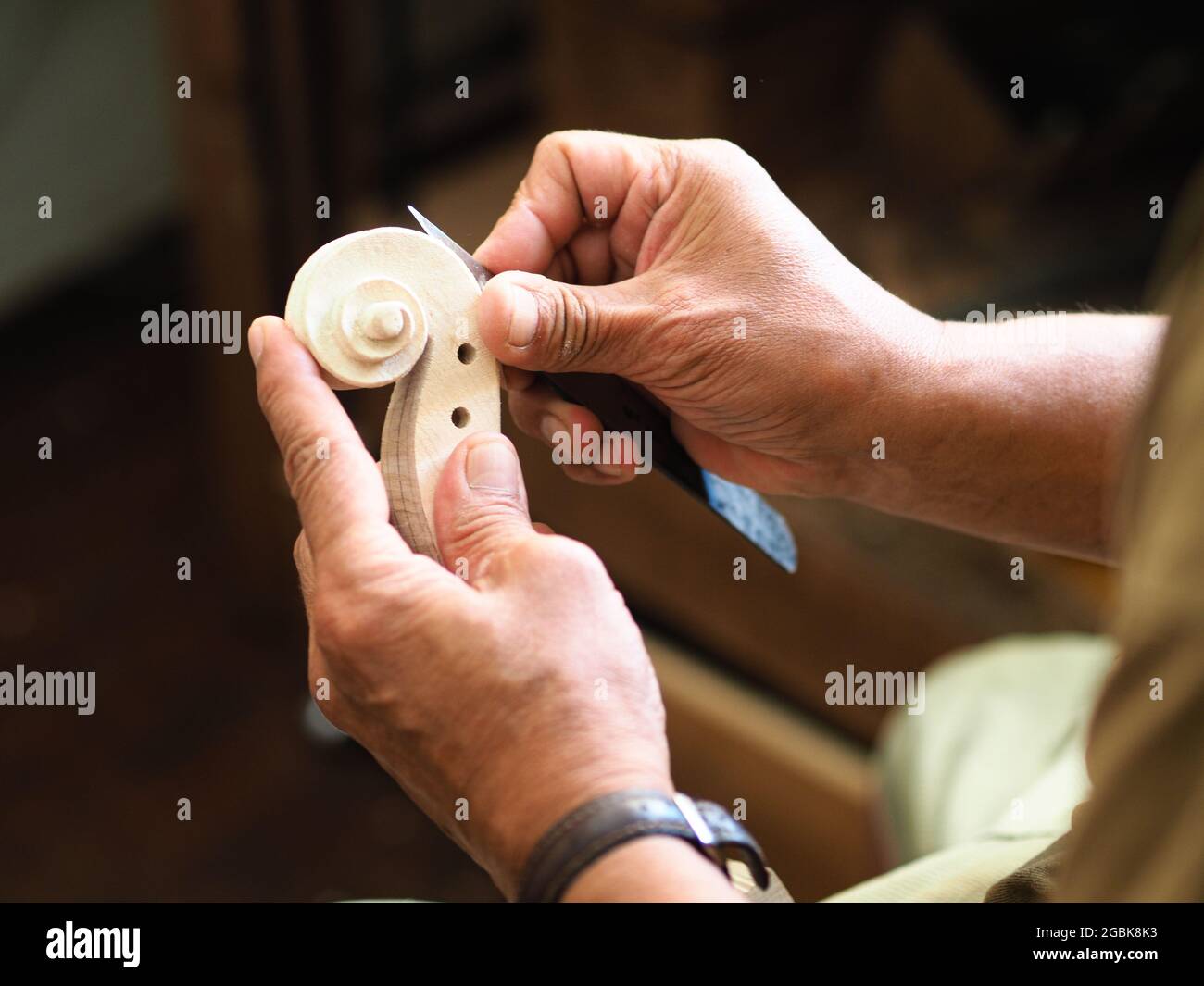 Luthier working on violin head and curl Stock Photo