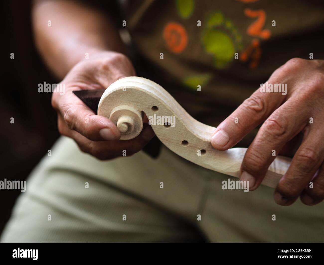 Luthier working on violin head and curl Stock Photo