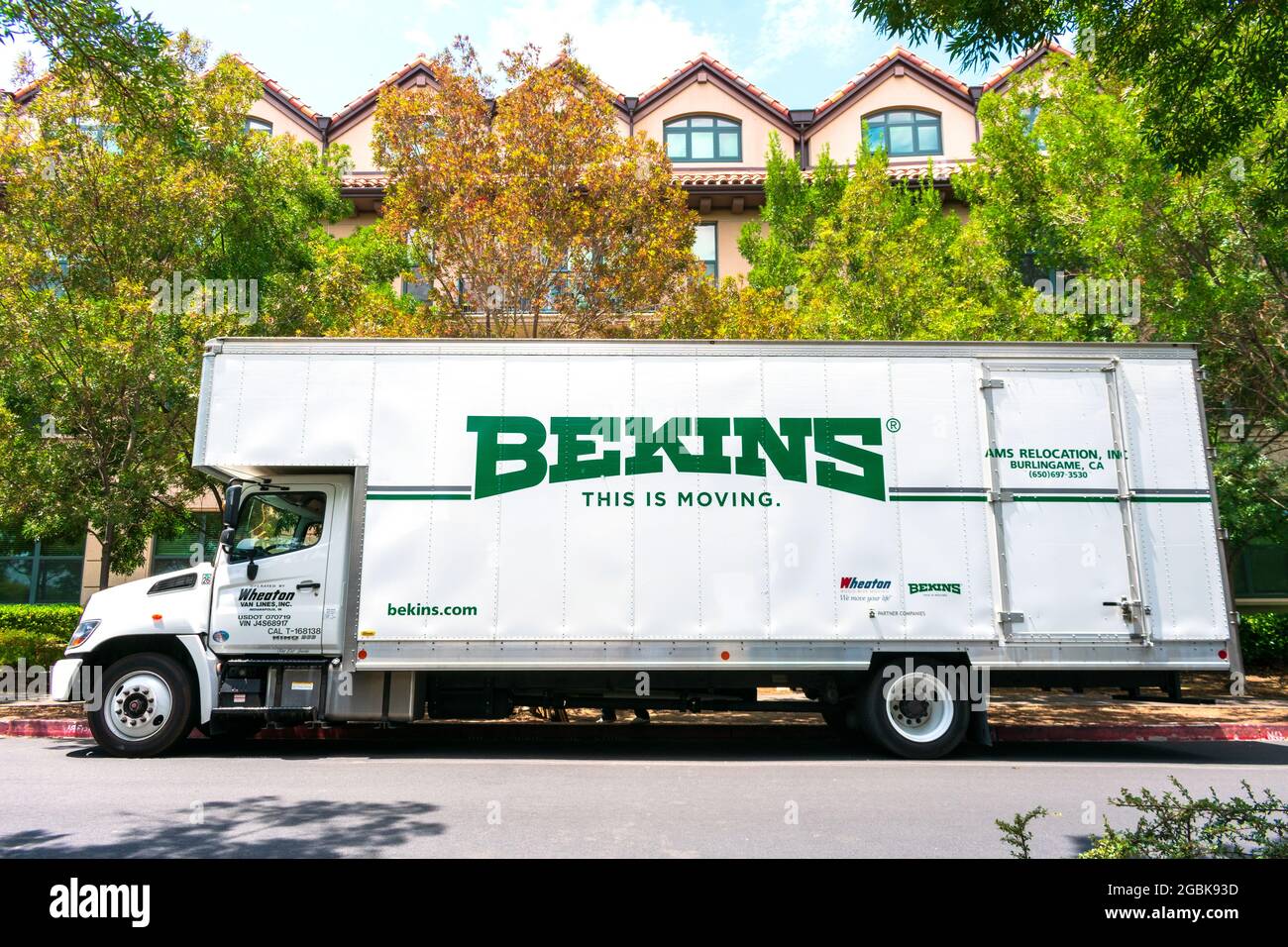 Bekins Van Lines moving company truck waits for customers at an outdoor parking lot near an apartment. Bekins is a nationwide moving company. - San Jo Stock Photo
