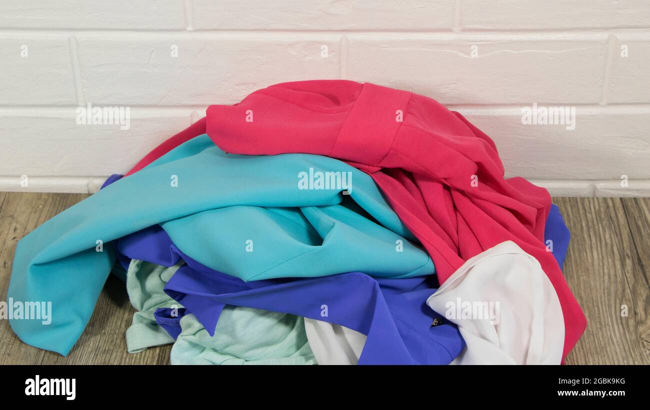 Throw clothes in a pile. A basic wardrobe. Minimalism. Clean up the closet. Sort the clothes. A mess. Women's clothing. Dirty laundry concept. A pile Stock Photo