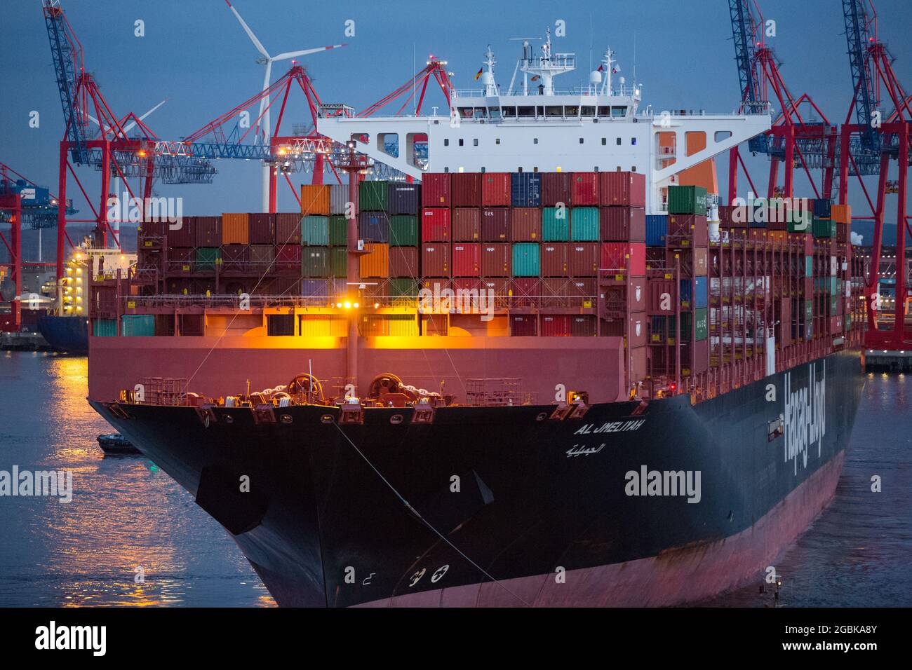 Hamburg, Germany. 14th Apr, 2021. Stacked containers stand on the container  ship Al Jmeliyah of the shipping company Hapag-LLoyd in the evening, while  the ship is towed by tugs on the Elbe