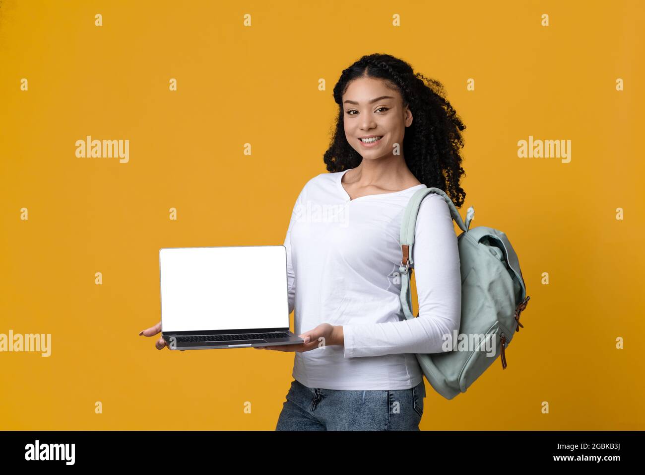 Online Education Website. Smiling Black Female Student Holding Laptop With Blank Screen Stock Photo