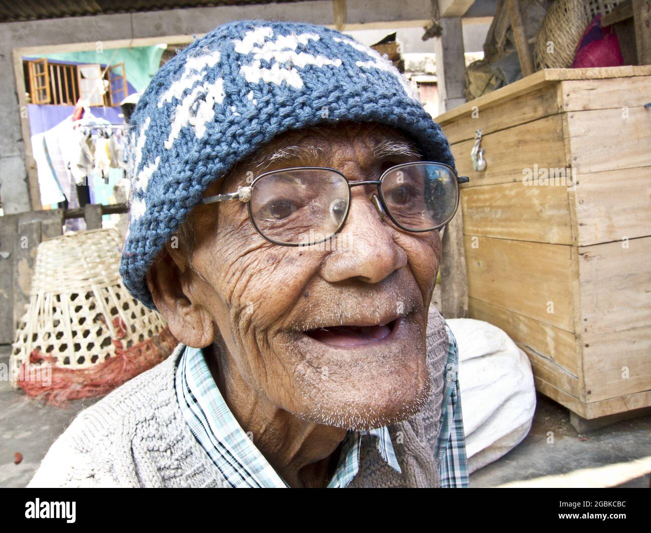 Darjeeling, India. Old man wearing glasses and beany smiling while walking  over the market. April 2012 Stock Photo - Alamy