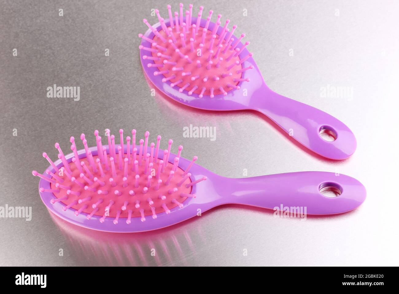 two purple hair brushes on metalic background Stock Photo Alamy