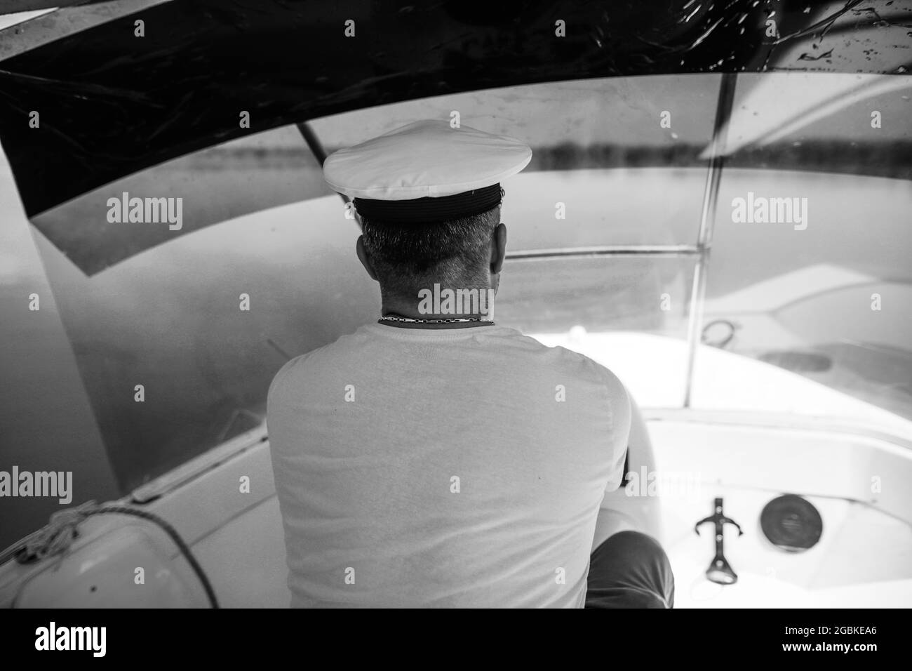 Shallow depth of field (selective focus) image with a small boat driver (captain,skipper). Stock Photo