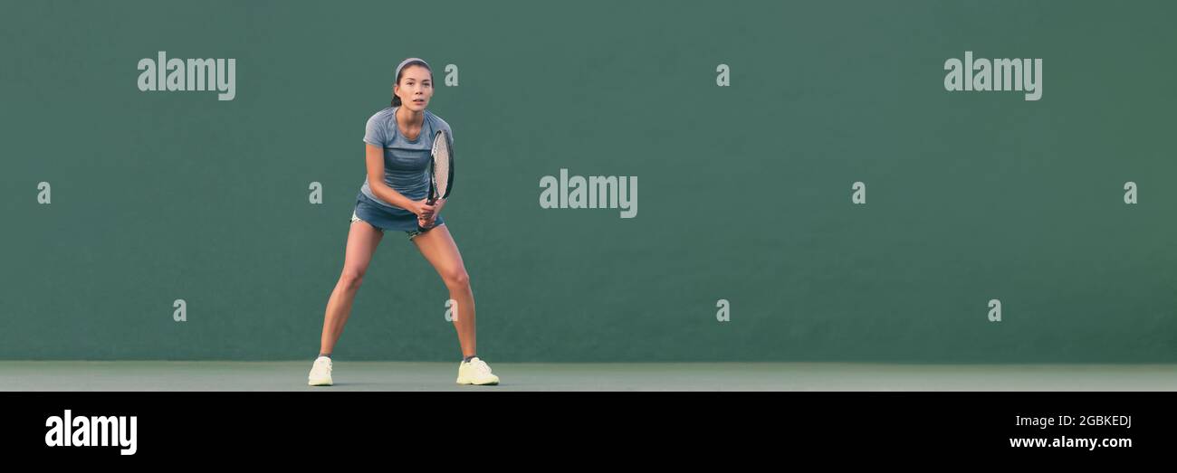 Tennis player woman ready to play in standing position. Female athlete waiting for serve on panoramic green background header banner. Challenge and Stock Photo
