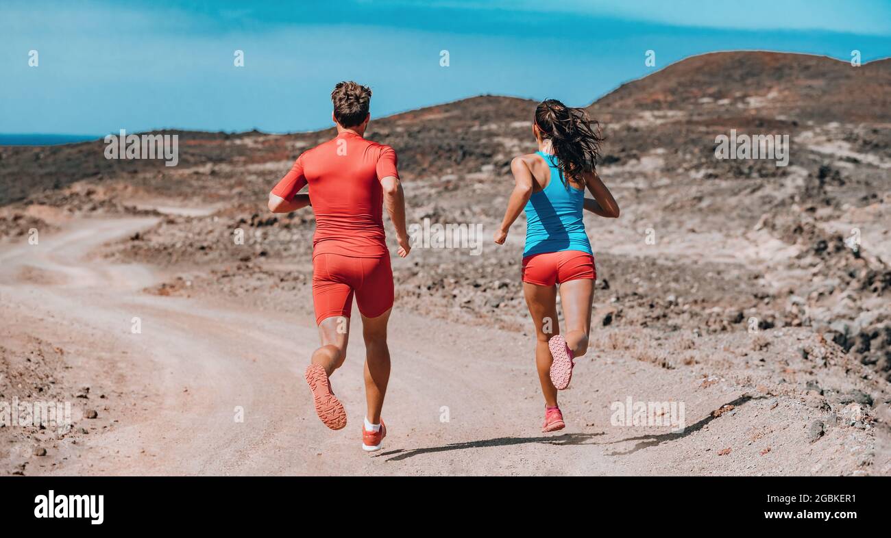 Trail running couple on outdoor exercise. Rear view of athletes