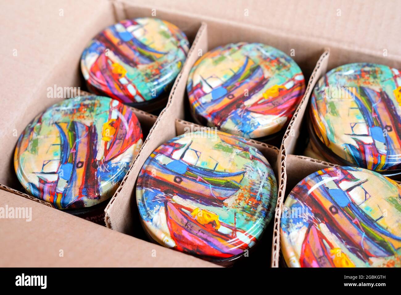 Beautiful lids for cans of canned food. Banks are in a box. Stock Photo
