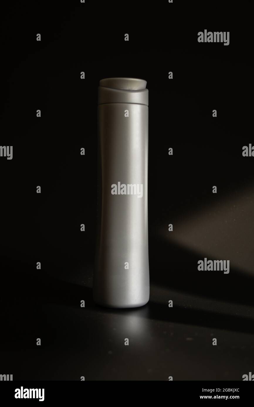 Vertical shot of a thermo bottle on a dark background Stock Photo