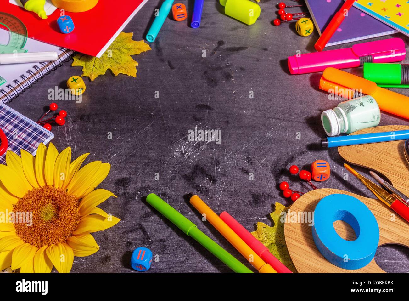 School supplies on a black chalkboard background. Pencils, paints, scissors, and colored notebooks. Back to school concept, copy space Stock Photo