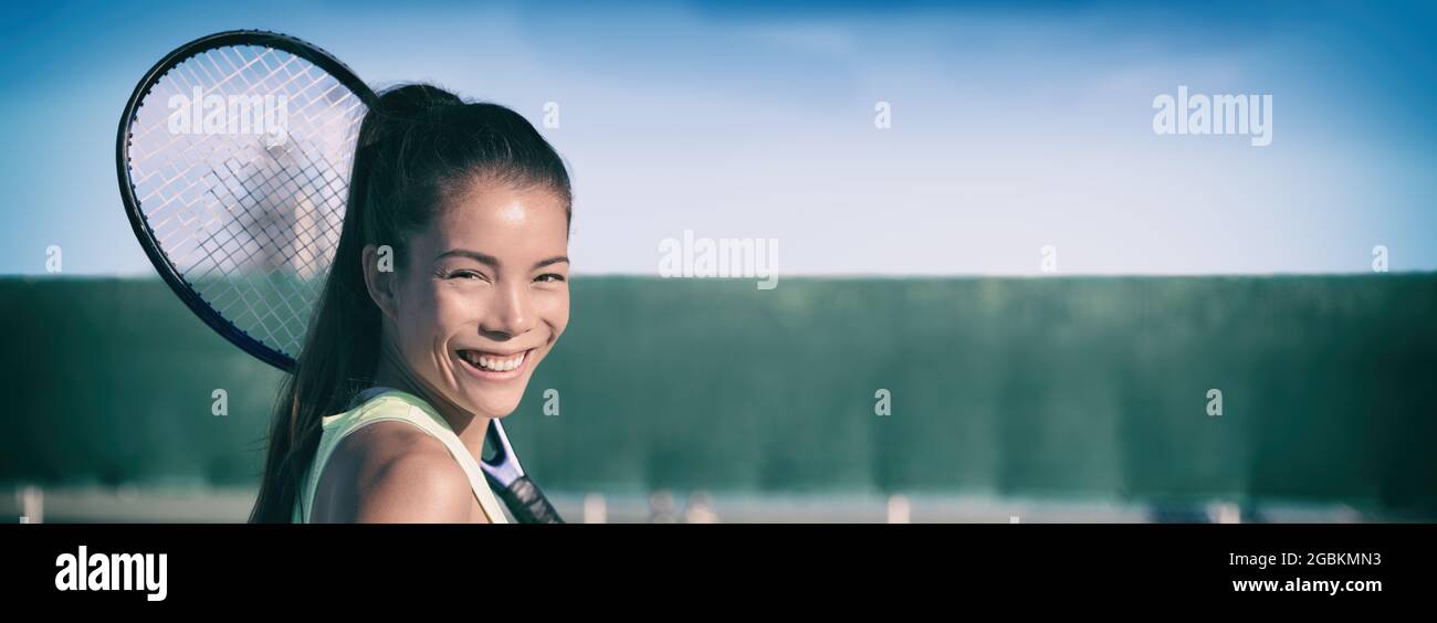 Tennis club happy Asian girl with racket smiling for lesson at indoor hard court panoramic banner. Sports athlete woman header Stock Photo