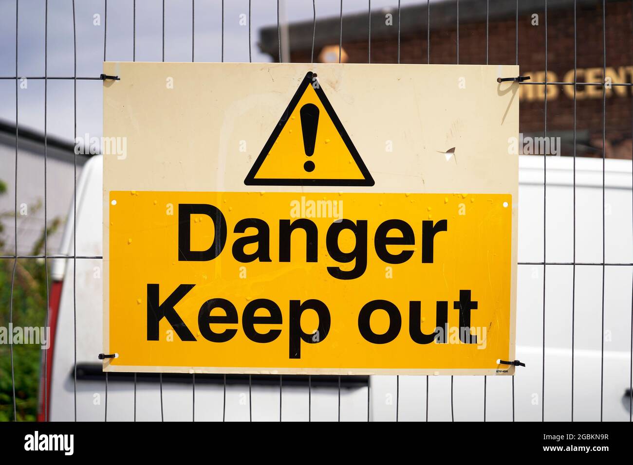 Danger keep out sign attached to a wire fence with cable ties Stock Photo