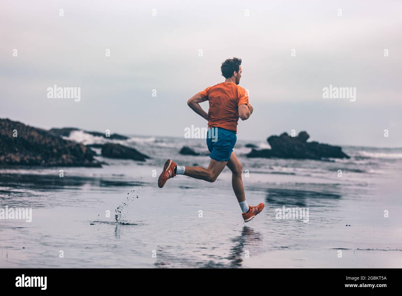 Exercise outdoor athlete man running on wet sand at beach training cardio  sprinting fast. Profile of runner in sportswear clothes jogging Stock Photo  - Alamy