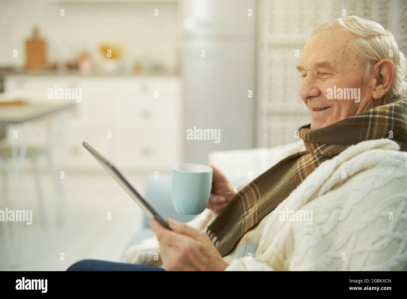 Smiling male pensioner using tablet to communicate with doctor Stock Photo