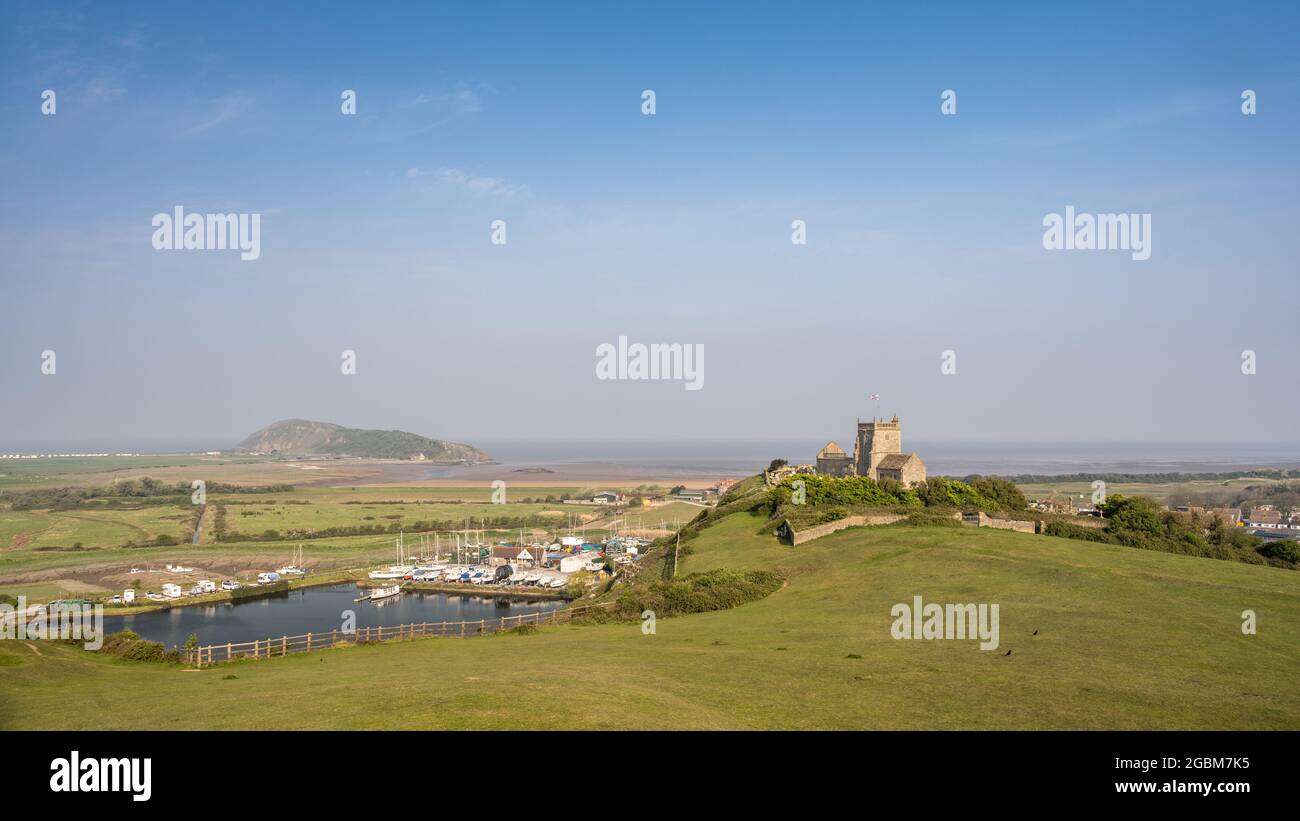 Morning sun shines on the ruins of St Nicholas Church, Uphill, above Brean Down and Weston-Super-Mare bay in Somerset. Stock Photo