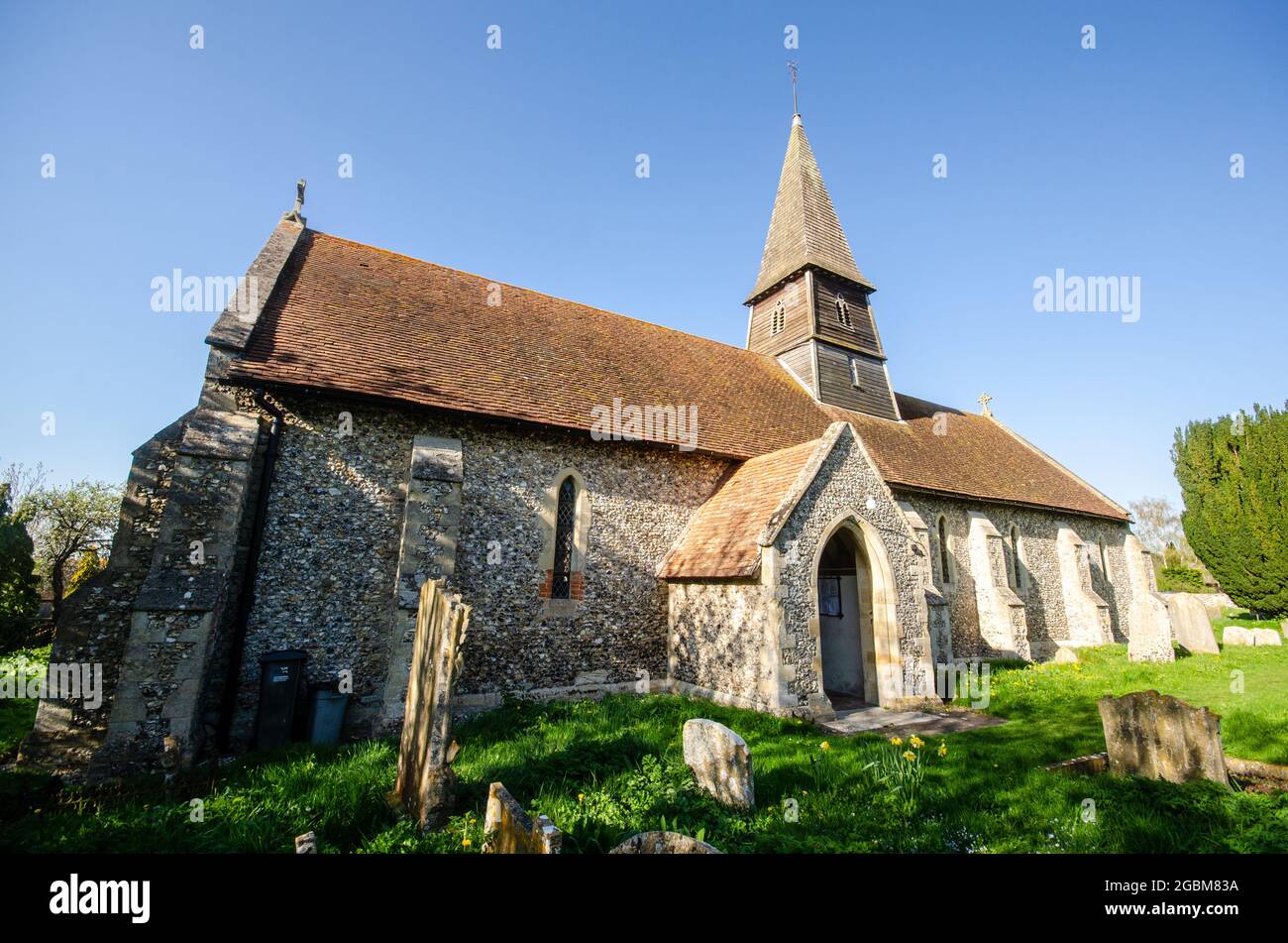 Thame, England, UK - April 18, 2015: Spring sunshine on the church, spire and graveyard of St Mary's Church in Sydenham, near Thame, Oxfordshire. Stock Photo