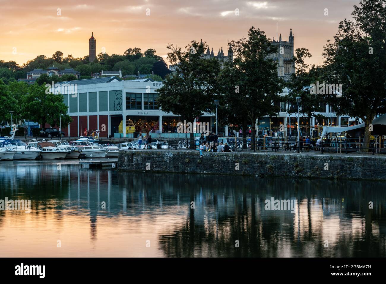 People drink on the quaysides of Bristol's Harbouside nightlife neighbourhood at sunset. Stock Photo