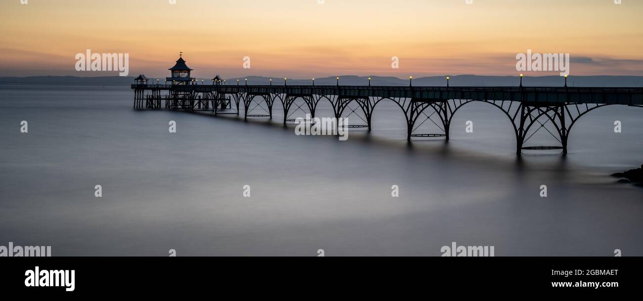The sun sets over the Bristol Channel and South Wales at Clevedon Pier in Somerset, England. Stock Photo