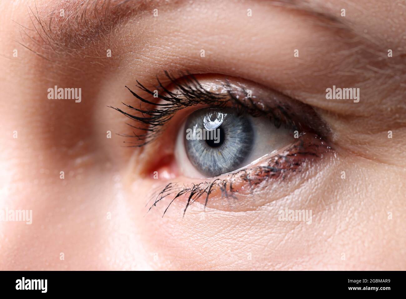 Beautiful blue female eye looking somewhere into distance Stock Photo