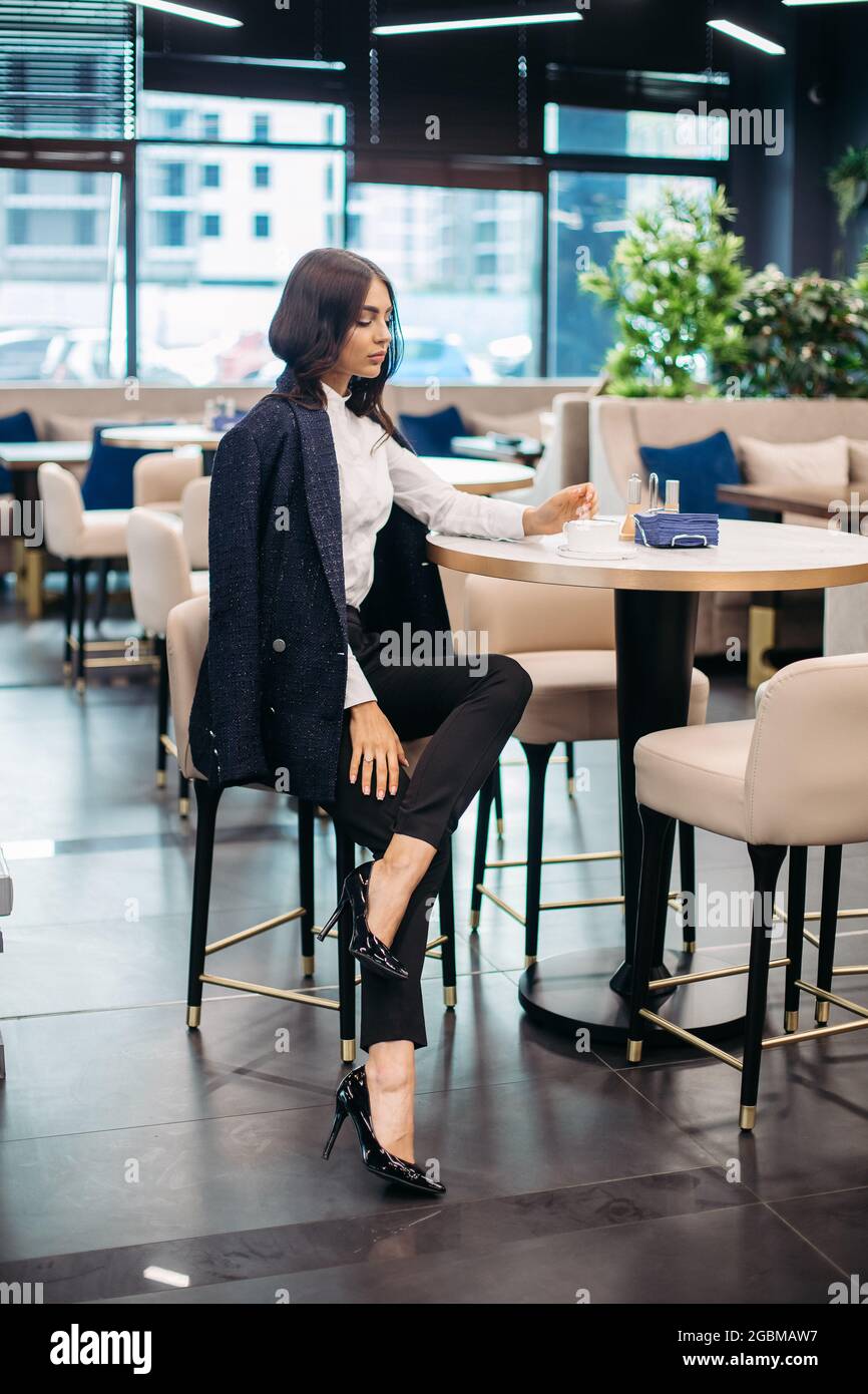 Pretty young lady in classic clothes in a restaurant Stock Photo