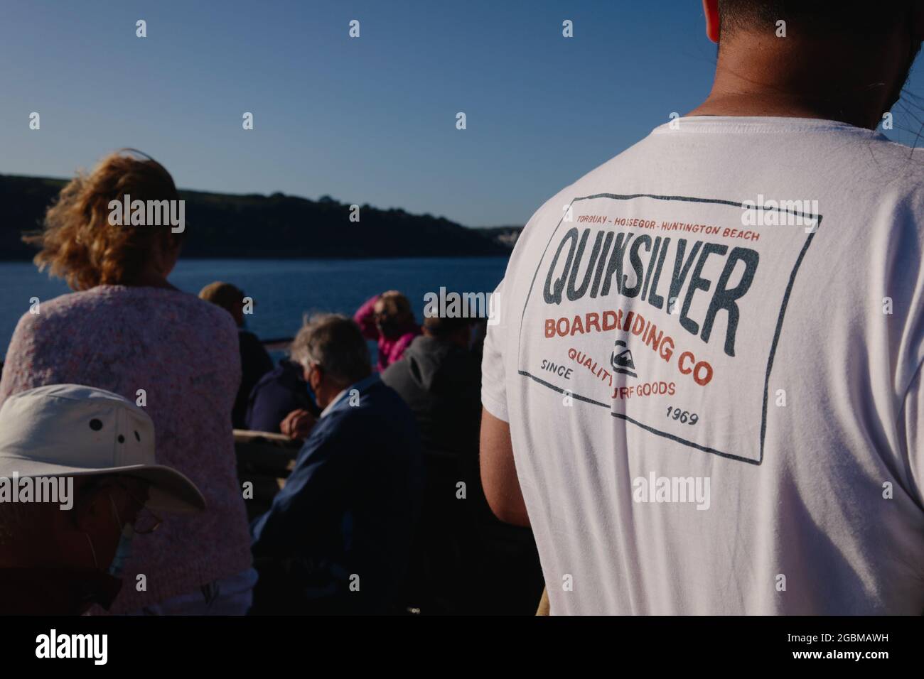 The back of a man wearing a Quiksilver t-shirt onboard the Scillonian III ferry between Isles of Scilly and Penzance, Cornwall, England, UK, July 2021 Stock Photo