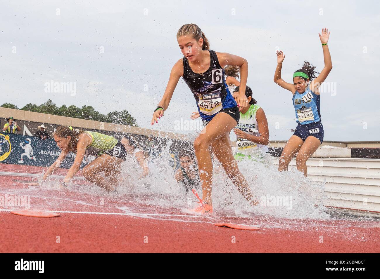August 4, 2021: Competitors navigate the water hazard during the Girls 2000 Meter Steeplechase 15-16 years old division in the 2021 AAU Junior Olympic Games at George Turner Stadium in Houston, Texas. Prentice C. James/CSM Stock Photo