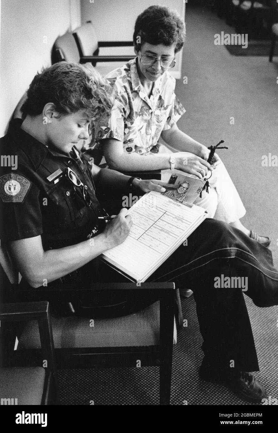 Austin Texas USA, circa 1992: Female police officer in uniform writes up a report at police station. ©Bob Daemmrich Stock Photo
