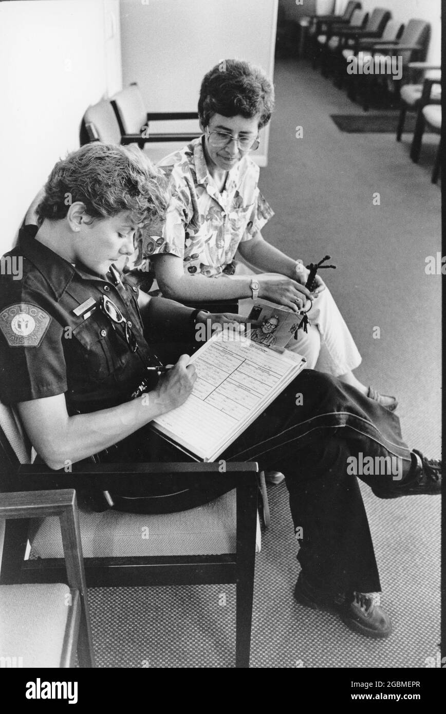 Austin Texas USA, circa 1992: Female police officer in uniform writes up a report at police station. ©Bob Daemmrich Stock Photo